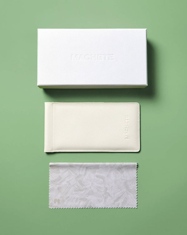 Set of white glasses cases and cleaning cloth on a green background