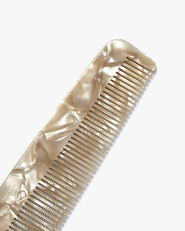 Gold comb with a reflective surface on a white background